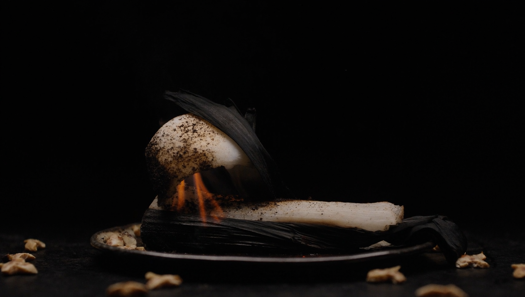Charred whole leeks pulled from the embers, dressed in ash vinaigrette