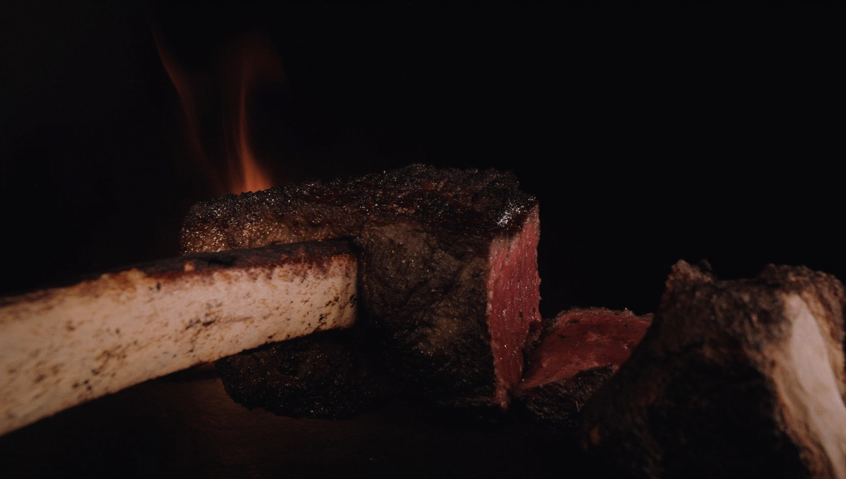 Aged beef rib cooked over live fire with a charred crust