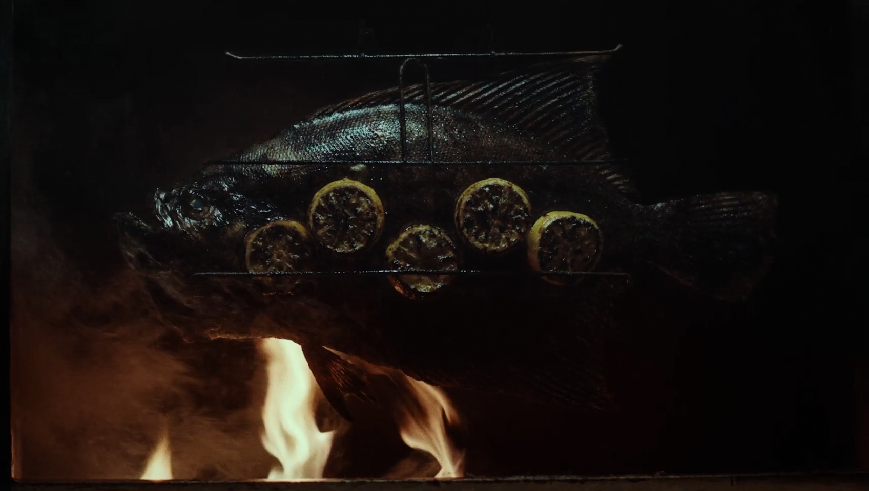 Whole turbot grilled over open flame, glossy and charred
